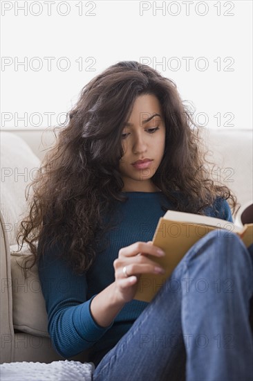 Woman reading book at home. Photo: Rob Lewine