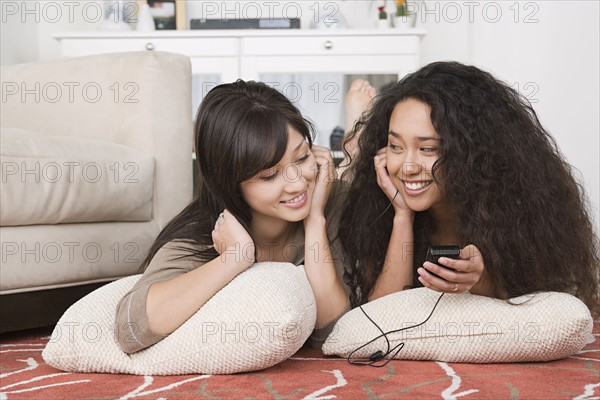 Young women listening to mp3 together. Photo : Rob Lewine