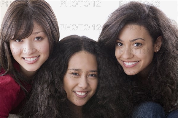 Studio portrait of three young women smiling. Photo : Rob Lewine