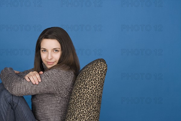 Portrait of teenage girl (16-17) sitting on chair. Photo: Rob Lewine