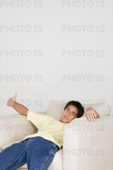 Teenage boy (16-17) relaxing in armchair. Photo : Rob Lewine