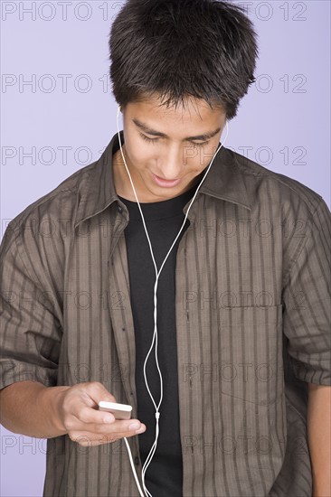 Teenage boy (16-17) listening to mp3 player. Photo: Rob Lewine