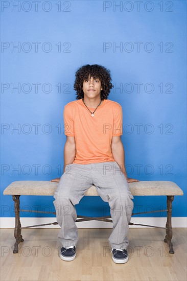 Portrait of teenage boy (14-15) sitting on bench. Photo : Rob Lewine