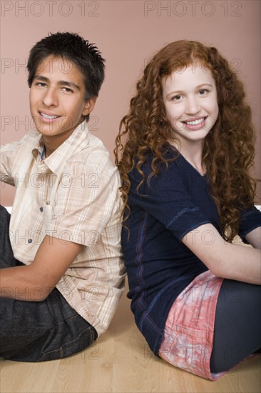 Portrait of teenage (16-17) girl and teenage boy (16-17) sitting together. Photo: Rob Lewine