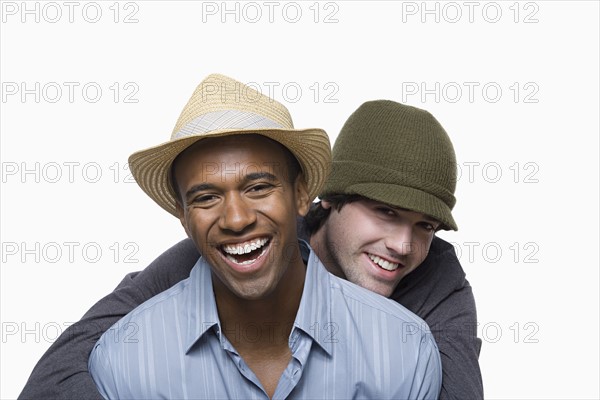 Studio portrait of two young men embracing. Photo : Rob Lewine