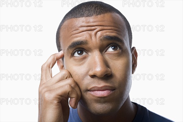 Studio portrait of young man contemplating. Photo : Rob Lewine