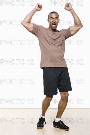 Studio portrait of young man cheering. Photo : Rob Lewine