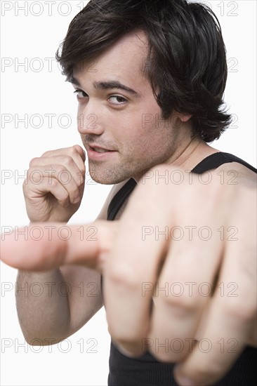 Studio portrait of young man punching air. Photo : Rob Lewine