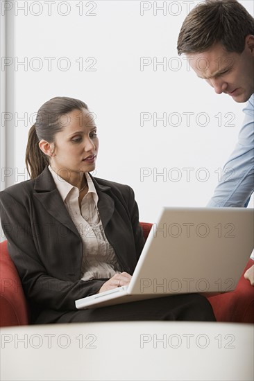 Two business people with laptop in office. Photo : Rob Lewine