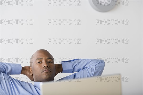 Businessman relaxing in office. Photo: Rob Lewine