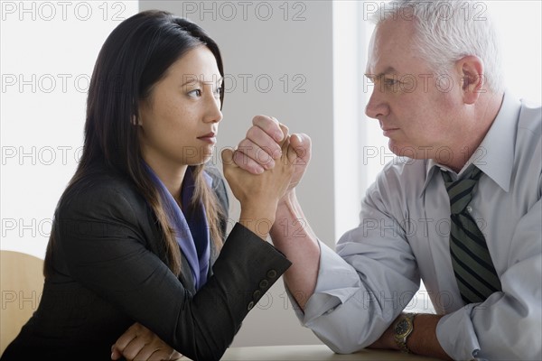 Business people arm wrestling. Photo : Rob Lewine