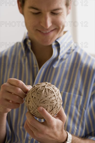 Young man holding ball made of paper. Photo : Rob Lewine