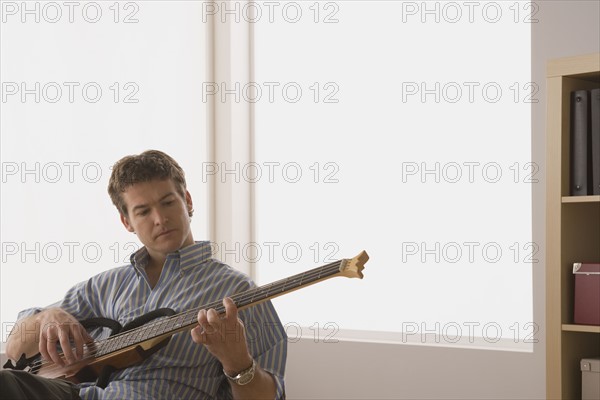 Young man playing electric base guitar. Photo : Rob Lewine