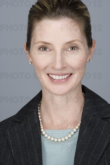 Portrait of cheerful mature businesswoman. Photo : Rob Lewine