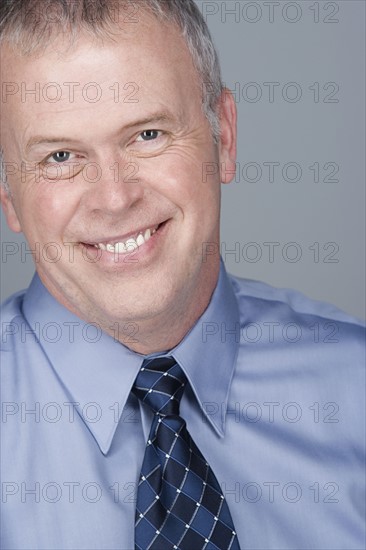 Portrait of happy mature businessman. Photo: Rob Lewine