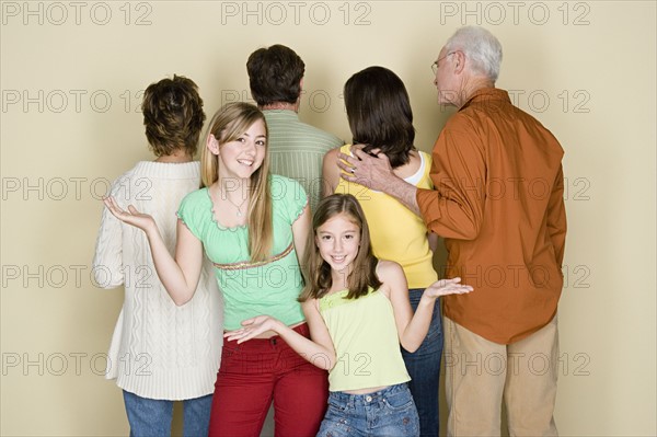 Two girls (8-9, 14-15) gesturing as rest of family is standing reversed. Photo : Rob Lewine