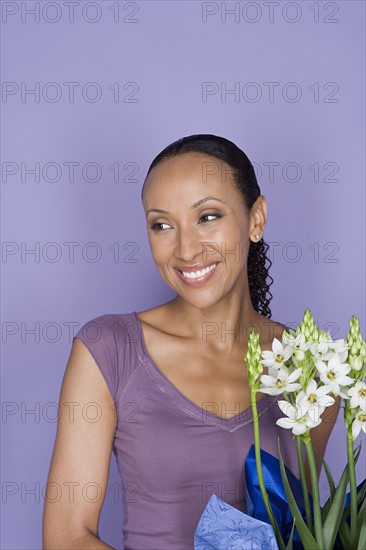 Portrait of happy african woman with flowers. Photo : Rob Lewine