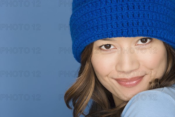 Portrait of happy asian woman wearing blue knit hat. Photo: Rob Lewine