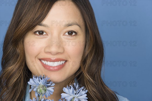 Portrait of happy asian woman with flowers. Photo : Rob Lewine