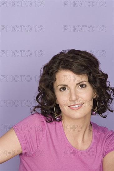 Portrait of smiling woman on purple background, studio shot. Photo: Rob Lewine