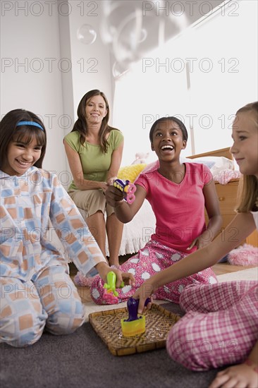 Three girls and woman (10-11) having fun at slumber party. Photo: Rob Lewine