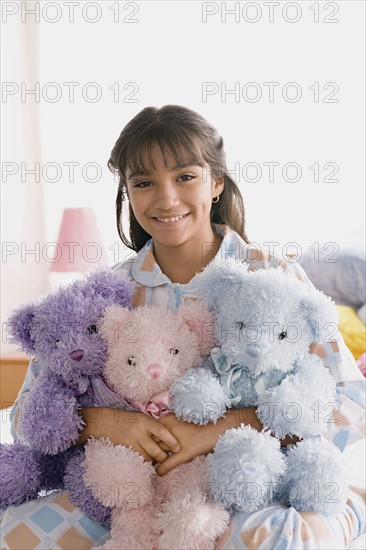 Portrait of smiling girl (10-11) holding puppets. Photo : Rob Lewine