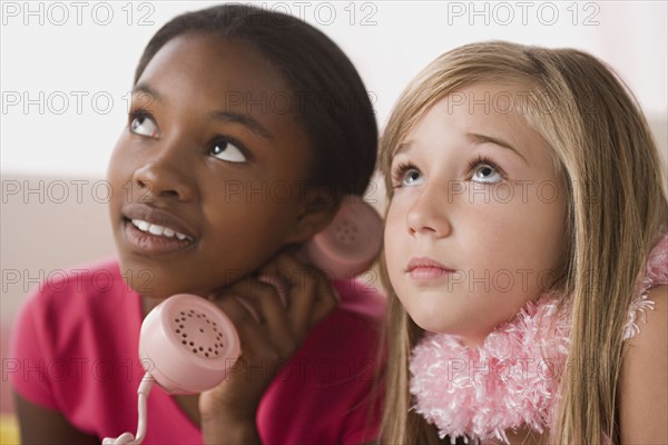 Portrait of two girls (10-11) using phone at slumber party. Photo: Rob Lewine