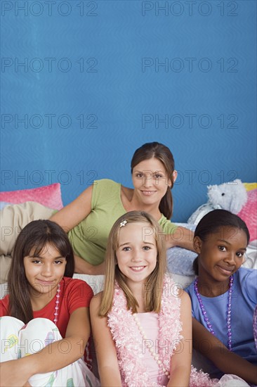 Portrait of woman and three girls (10-11) at slumber party. Photo: Rob Lewine