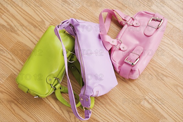 Close up of three colorful purses on parquet floor. Photo: Rob Lewine