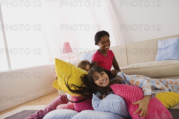 Three girls (10-11) playing on bed at slumber party. Photo : Rob Lewine