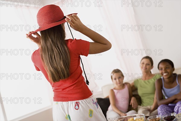 Three girls (10-11) and woman playing at slumber party. Photo: Rob Lewine