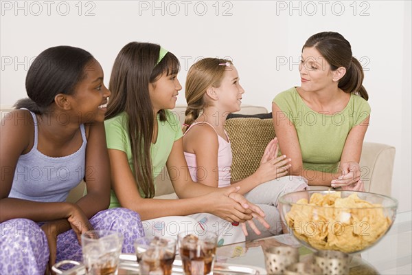Three girls (10-11) and woman at slumber party. Photo : Rob Lewine