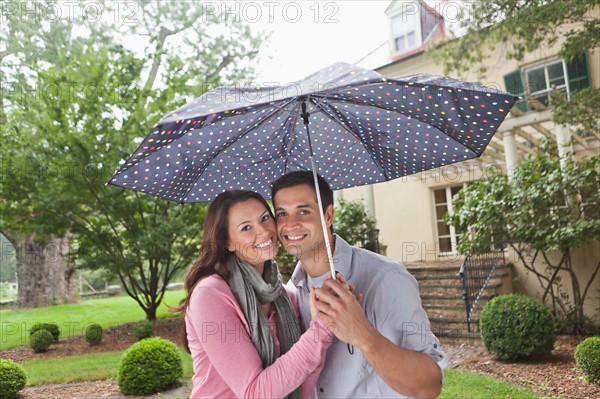 USA, New Jersey, Portrait of couple holding umbrella. Photo : Tetra Images