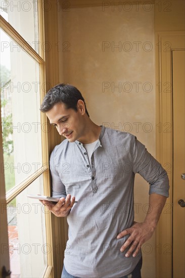Man reading e-book at home. Photo: Tetra Images