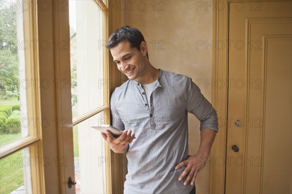 Man reading e-book at home. Photo : Tetra Images