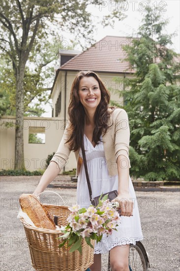 USA, New Jersey, Portrait of woman on bike with basket. Photo: Tetra Images