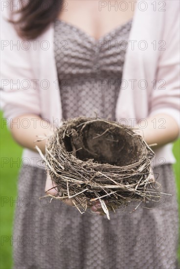 Happy woman standing on stone wall on field. Photo: Tetra Images