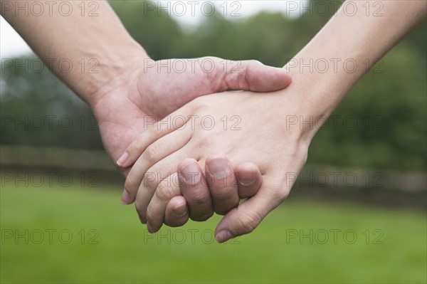 Close-up of couple holding hands. Photo: Tetra Images