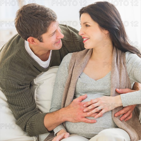 Man touching pregnant woman's belly.