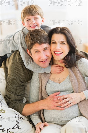 Portrait of parents with son (4-5) on sofa.