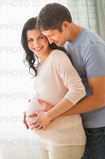 Man hugging pregnant woman.