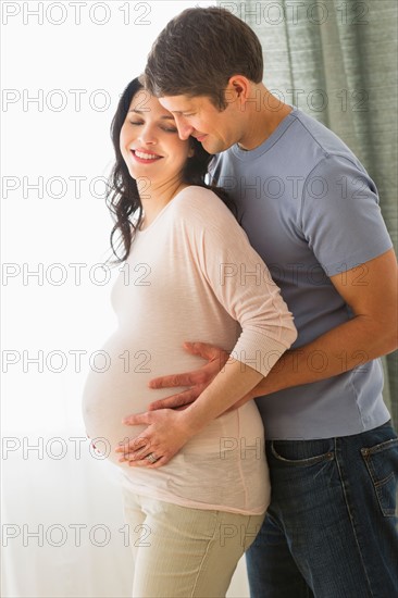 Man hugging pregnant woman.