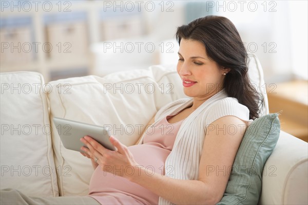 Pregnant woman using tablet pc.