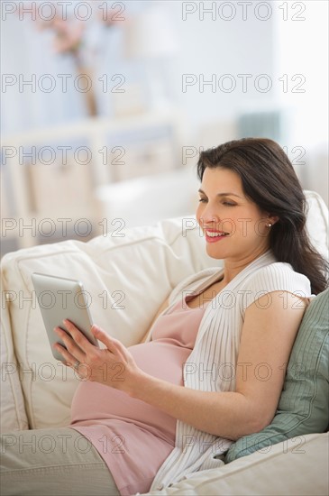 Pregnant woman using tablet pc.