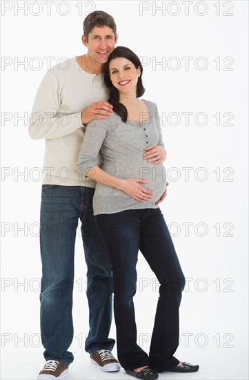 Studio portrait of man and pregnant woman.