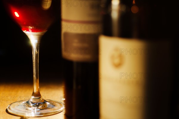 Studio shot of wine glass and bottles.