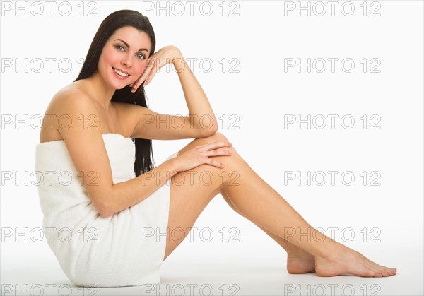 Studio portrait of young woman wrapped in towel.
