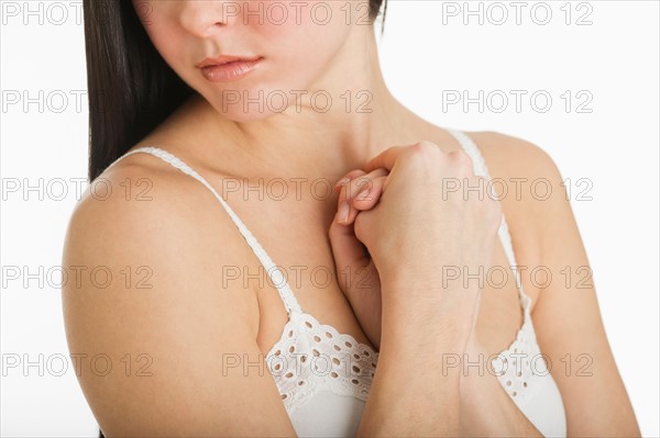 Studio shot of young woman caring for skin.