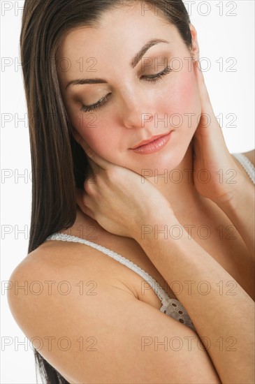 Studio shot of young woman caring for skin.