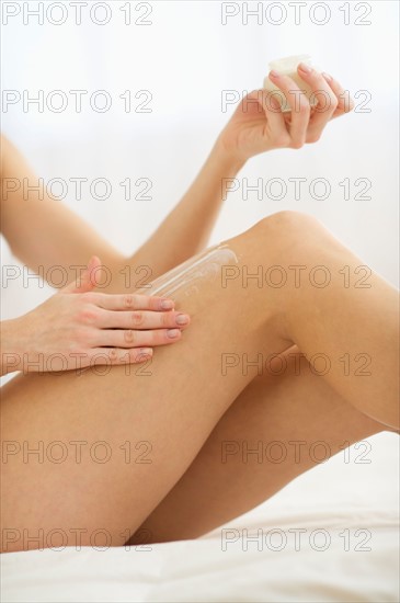 Studio shot of young woman caring for skin.
